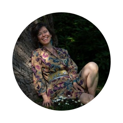 Noémie d’ELLAHNOE, assise contre un arbre, incarne une spiritualité ancrée dans la nature.